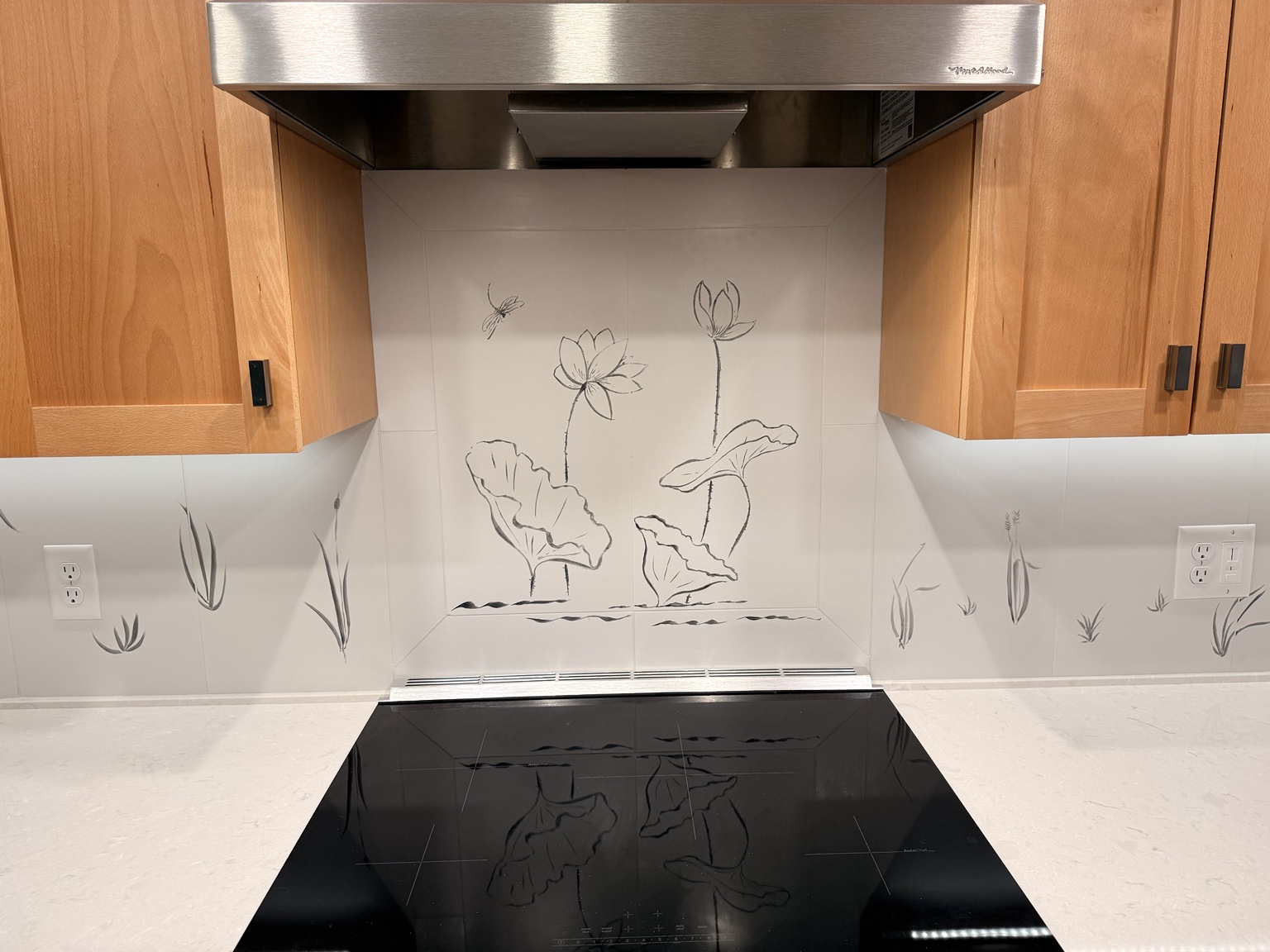 Close view of the botanical tile feature behind the range